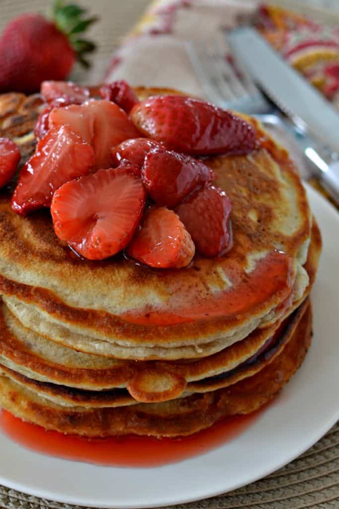 These light and fluffy strawberry pancakes are topped with fresh strawberries coated in a light and sweet sauce.