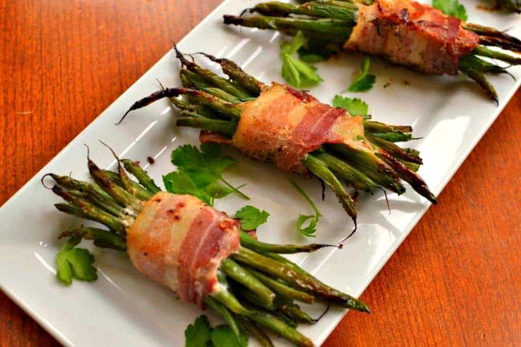 Three green bean bundles on a serving platter. 