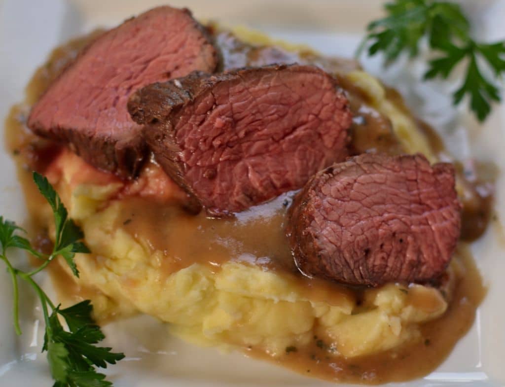 Tender, medium rare beef shoulder with homemade gravy served over mashed potatoes