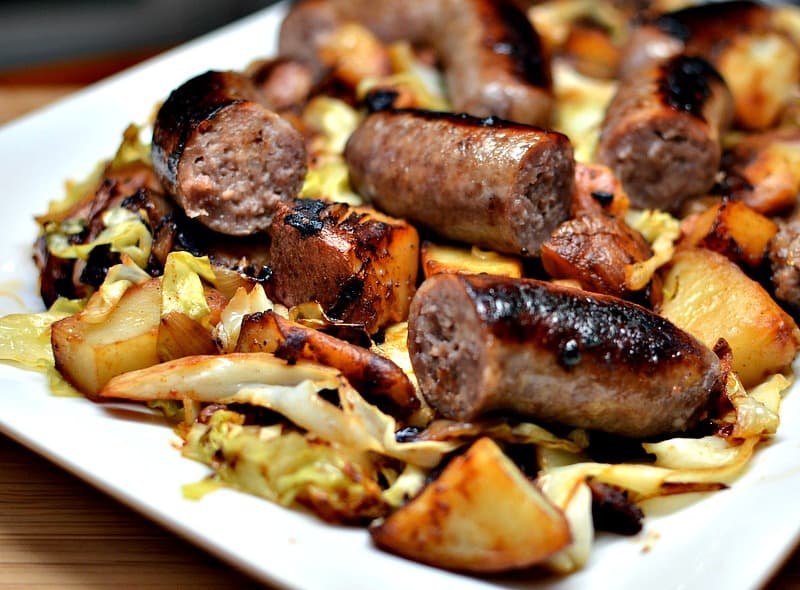 This Cabbage and Brats recipe combines beer brats, crispy cooked potatoes, onions, and sauteed cabbage in a lightly sweetened mustard sauce.