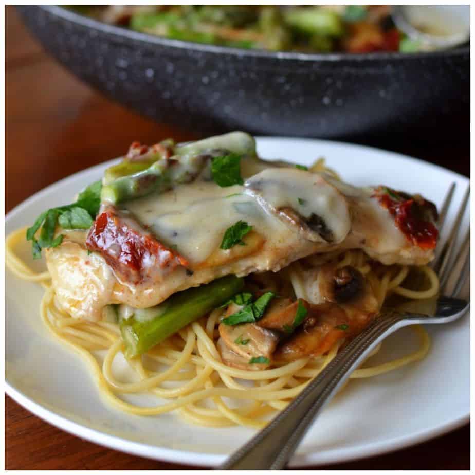 Serve this creamy mushroom chicken topped with tender asparagus and sun dried tomatoes over a bed a tender spaghetti