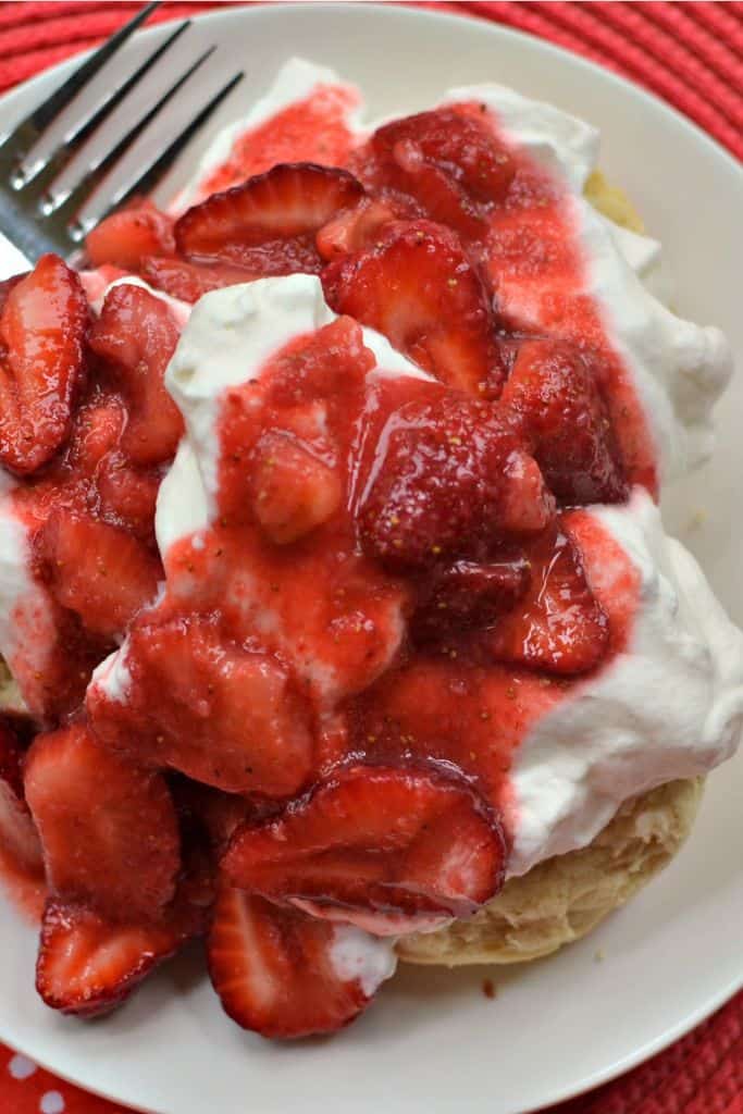 Sweet and juicy strawberries cover fresh whipped cream served over warm homemade buttermilk biscuits