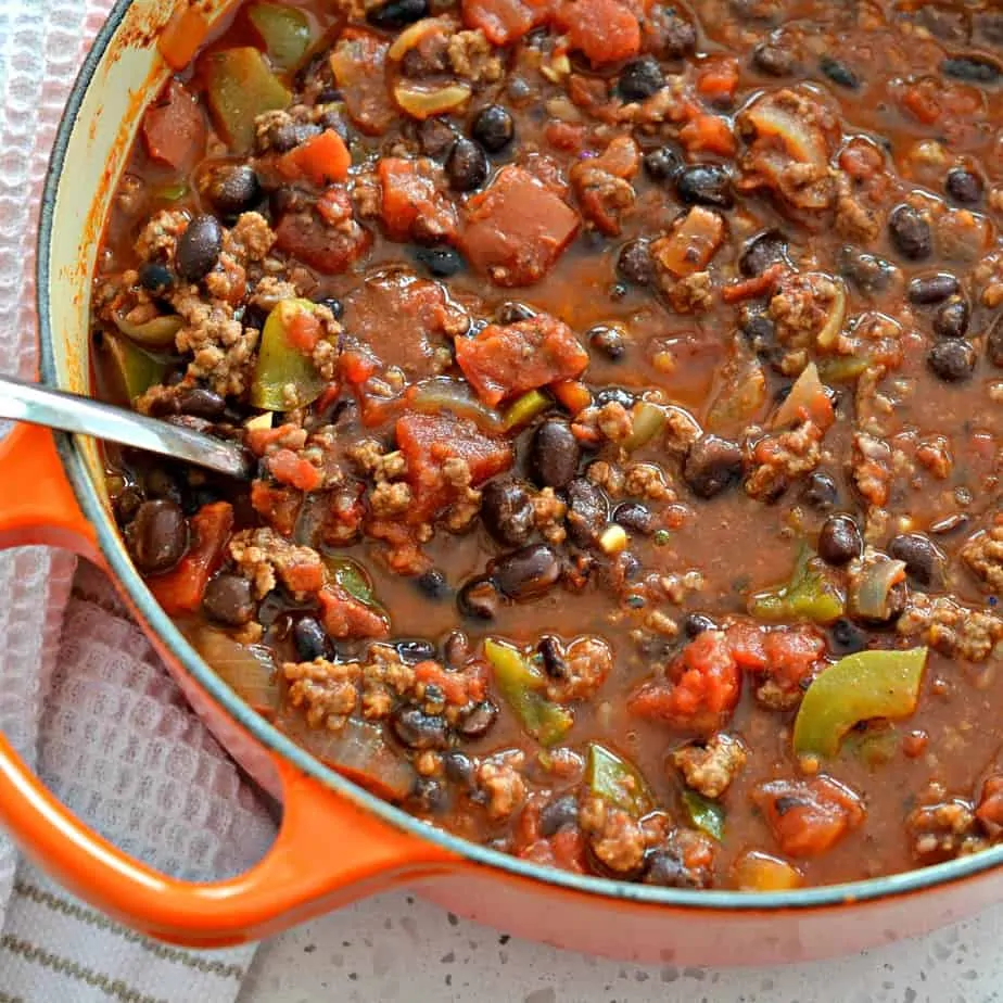 This Thick Hearty Chili Recipe is plump full of ground beef, black beans, tomatoes, onions, green bell peppers, and a perfect blend of spices