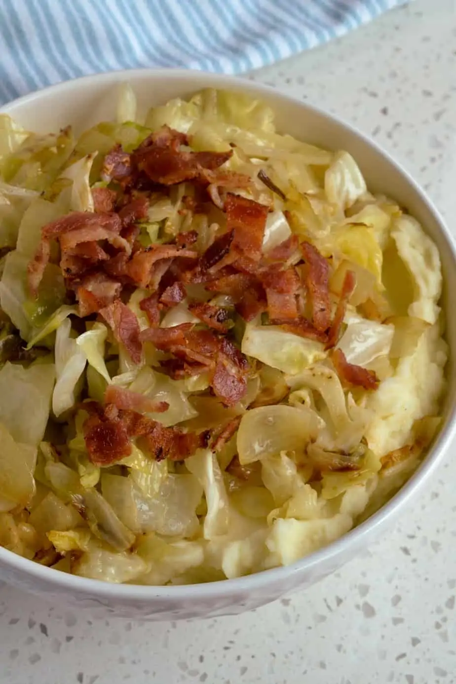 Irish Colcannon is made with mashed potatoes, fried cabbage, onions, crisp bacon and seasoned with salt and pepper.
