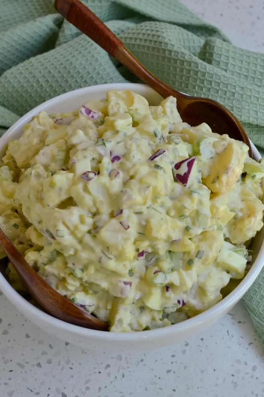 A bowl full of dill pickle potato salad. 