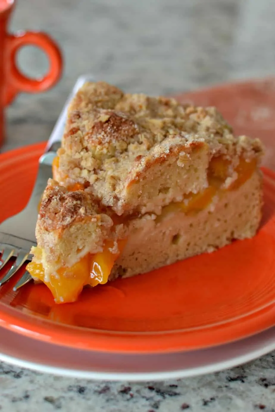 A family friendly sweet peach coffee cake with a sour cream base and a crunchy oatmeal crumb topping