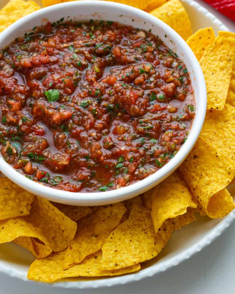 Fresh Garden Salsa Recipe A close up view of a bowl full of homemade tomato salsa surrounded by tortilla chips.