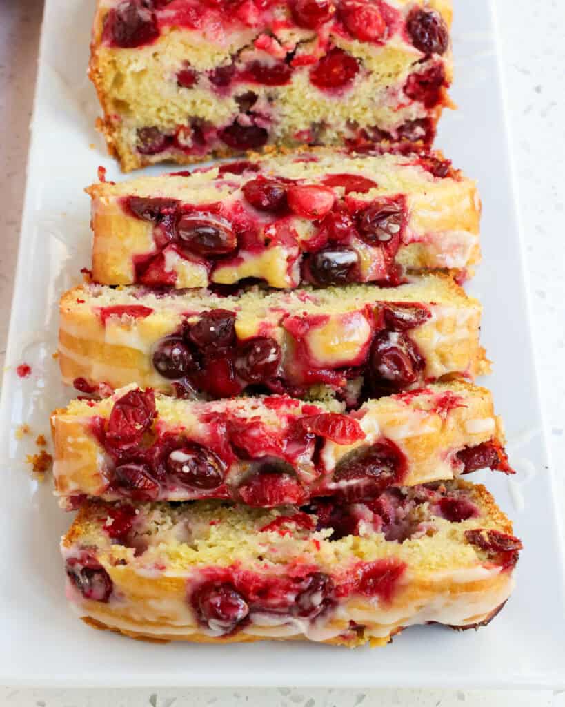 Slices of orange cranberry bread on a platter. 