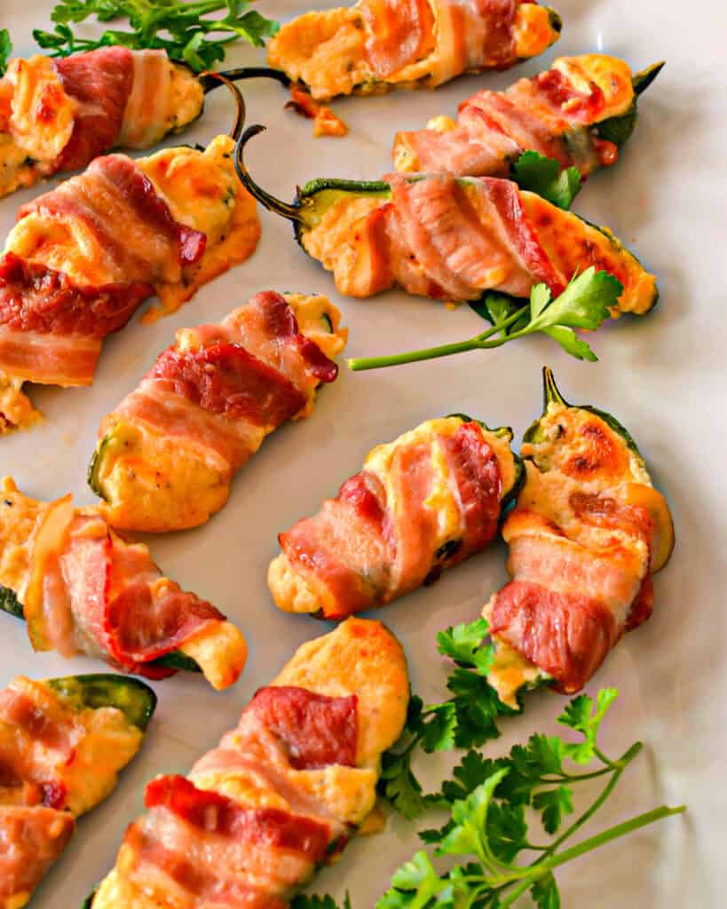 Distributed bacon-wrapped jalapenos with parsley garnishes.