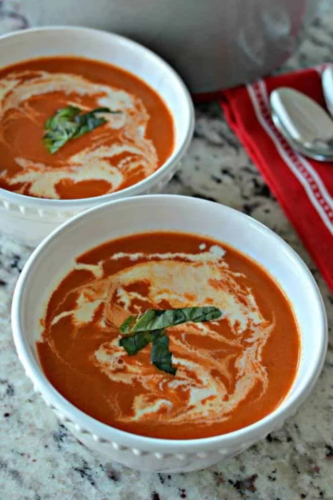 Drizzled with cream and topped with a ribbon of basil, this homemade tomato bisque soup is a creamy, delicious meal