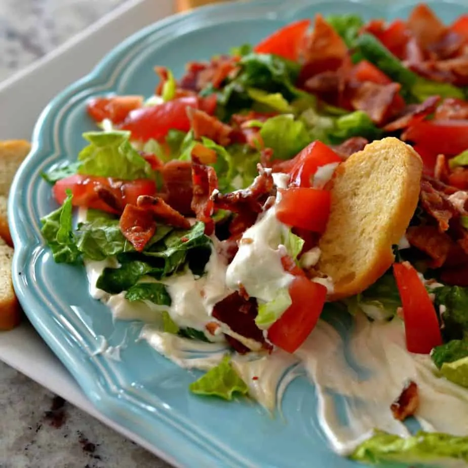 A creamy cream cheese base is layered with lettuce, bacon, and tomato