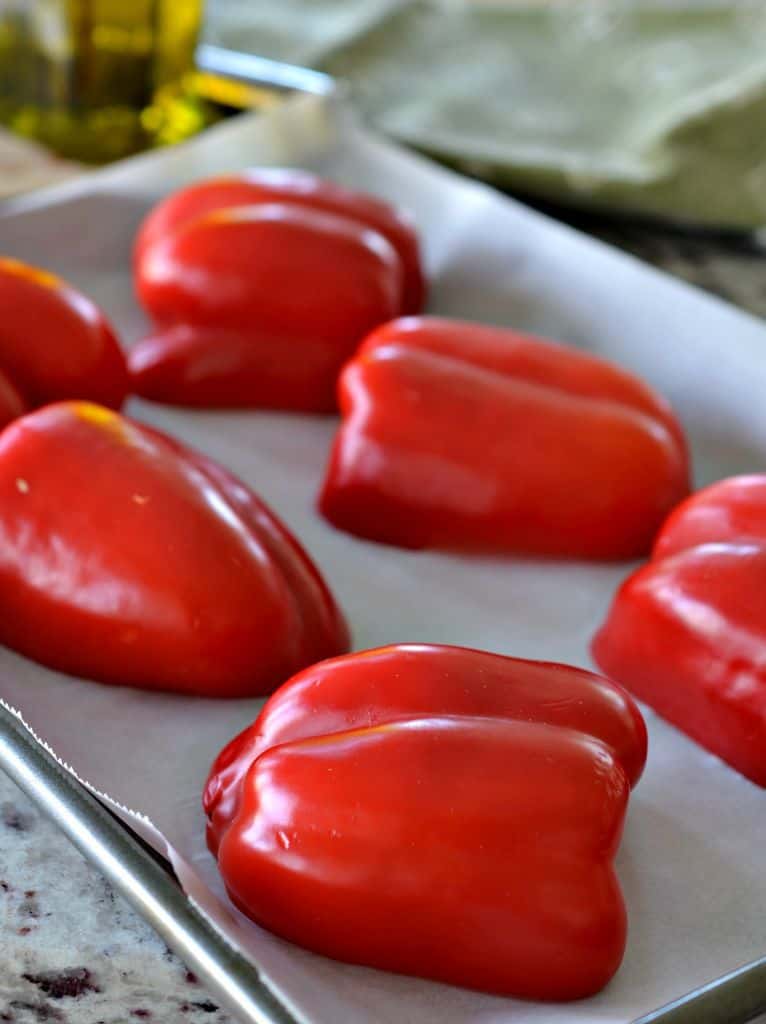Start with fresh, ripe red peppers cut in half and placed on a baking tray with parchment paper