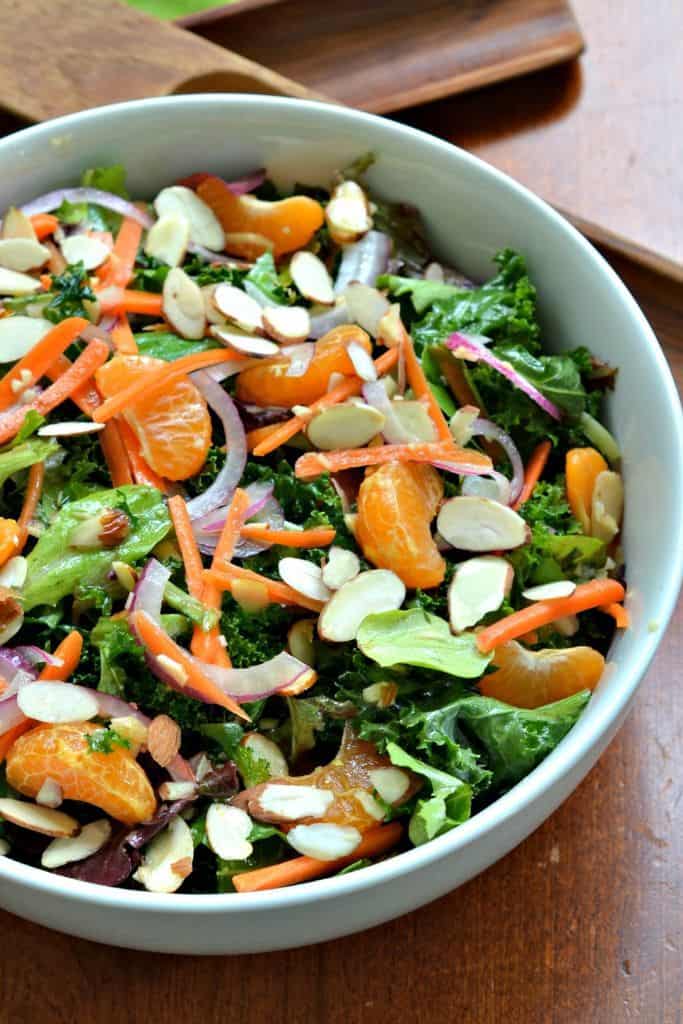 Topped with mandarin oranges, carrots, almonds, and a zesty ginger Vinaigrette, this kale salad is fresh and delicious