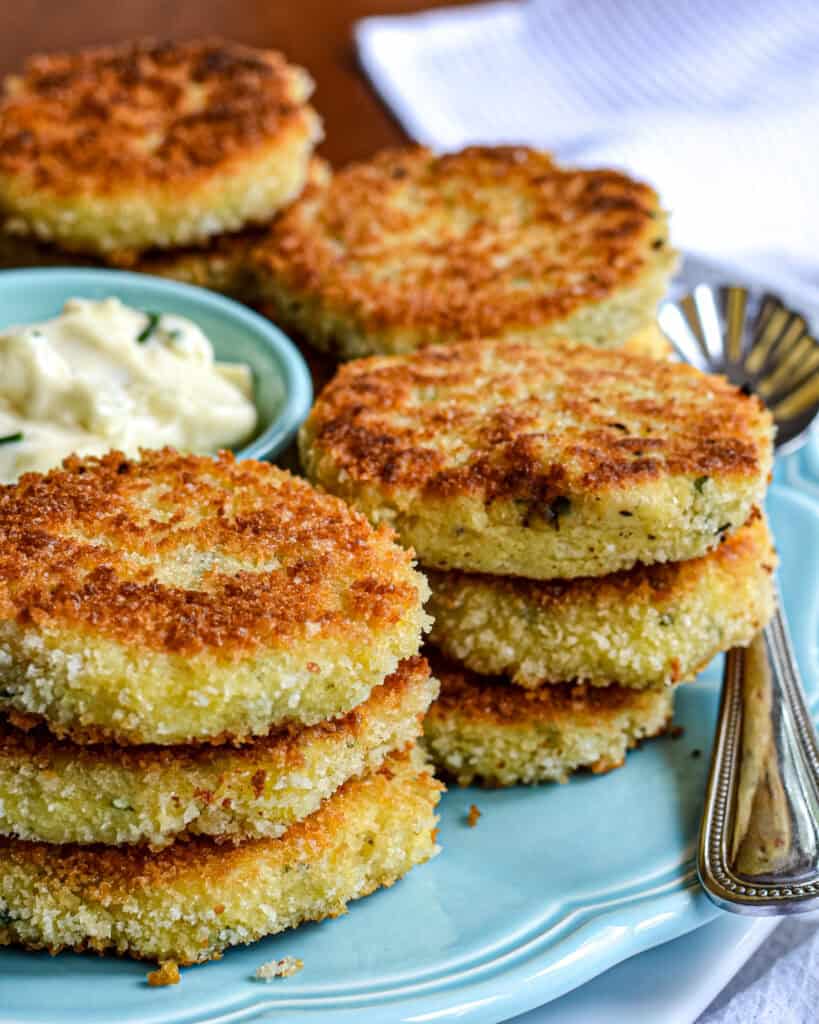 A close up view of the Potato Croquettes with a bowl of garlic aioli off to the left.
