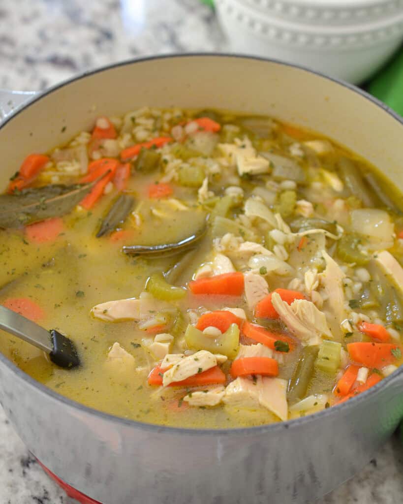 Chicken Barley Soup Recipe Chicken Barley Soup in a Dutch oven with a ladle in the pot.