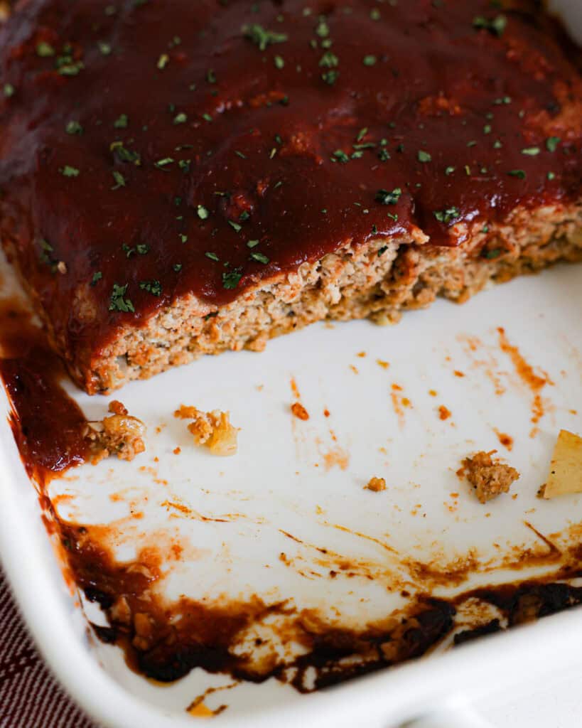 Glazed turkey meatloaf in a white baking dish. 