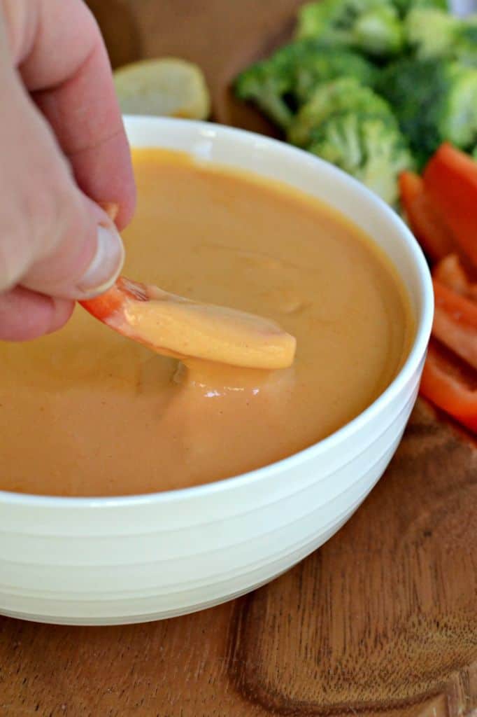 Beer Cheese Dip is delicious and served with crostini, pretzels, broccoli, pepper wedges, carrots, and celery sticks.