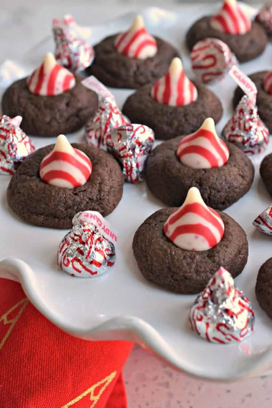 Fun holiday peppermint chocolate thumbprint cookies topped with a white chocolate peppermint kiss. 