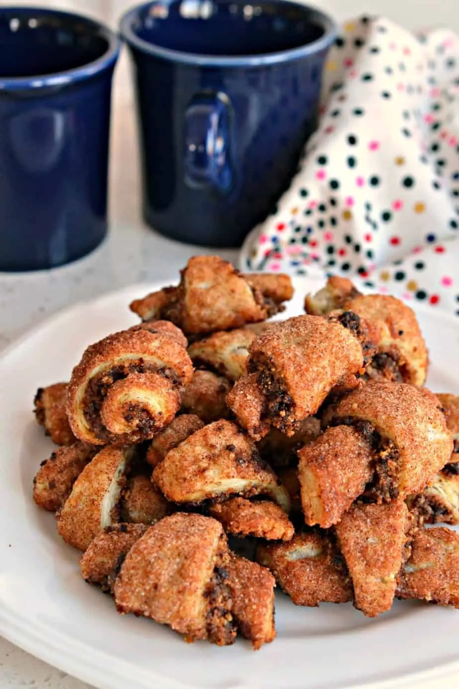 This Rugelach Recipe is an easy-to-make pastry cookie with a five-ingredient flaky butter crust wrapped around pecans, brown sugar, raisins, and cinnamon. 
