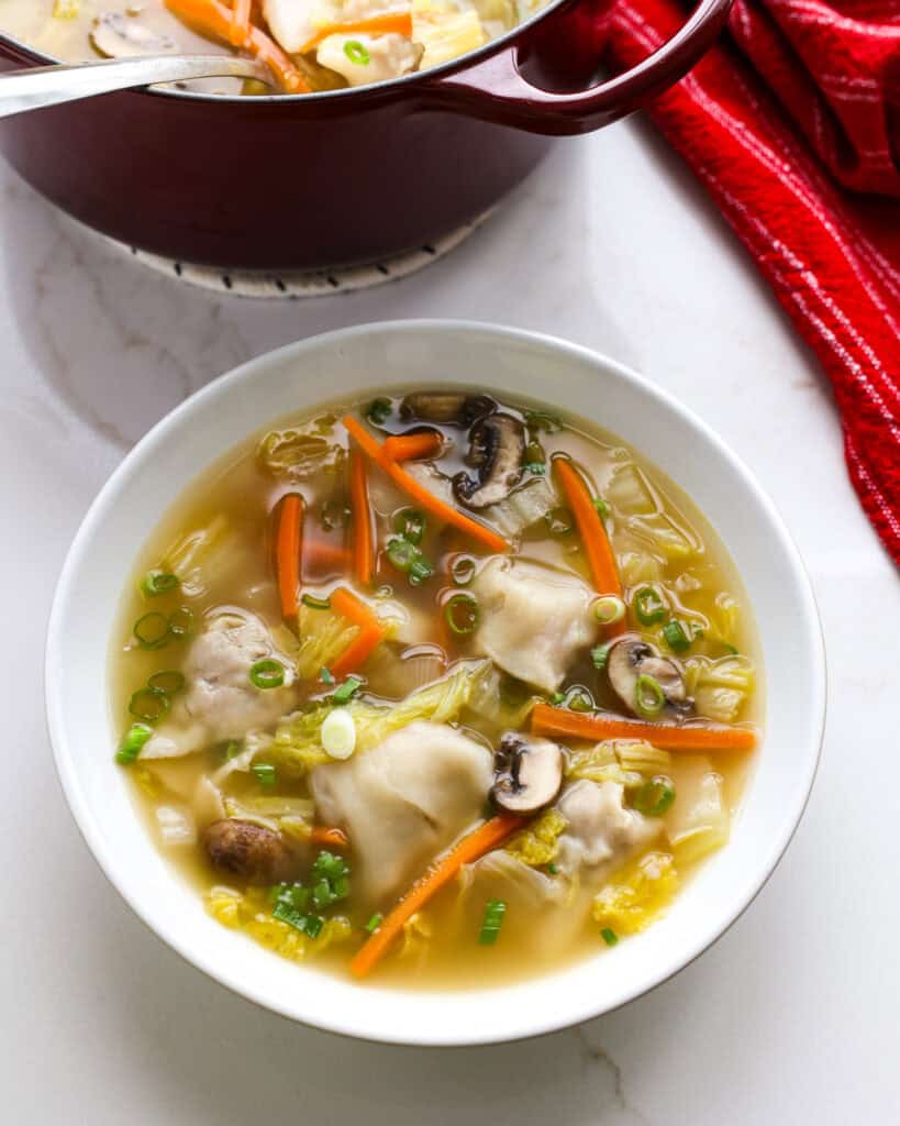 A close up view of a single serving bowl full of wonton soup. 