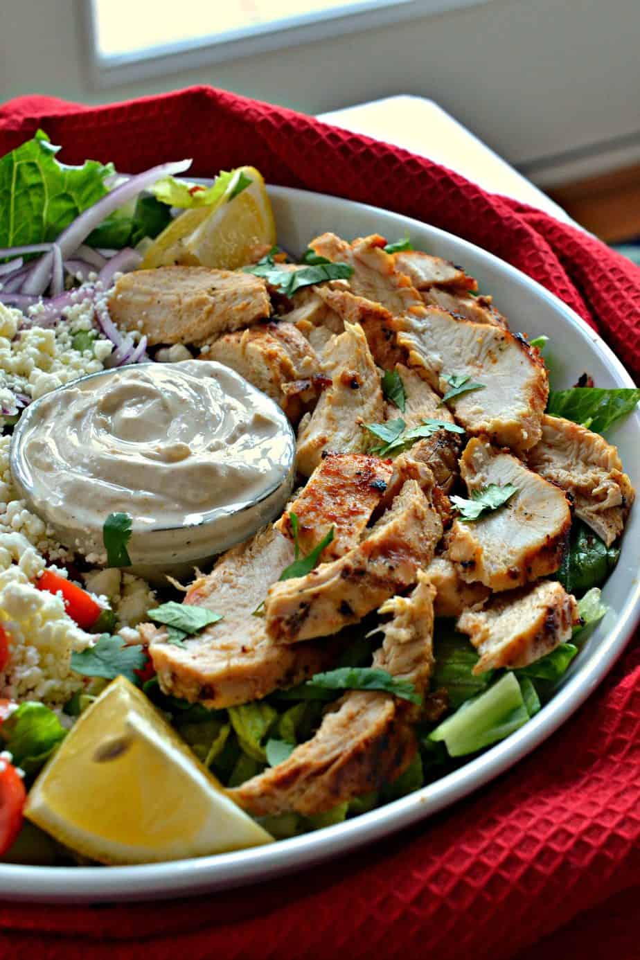 Marinated boneless skinless chicken breasts or thighs are grilled to perfection and served on soft pita bread with fresh yogurt sauce, tomatoes, cucumbers, sweet red onion, and feta cheese.