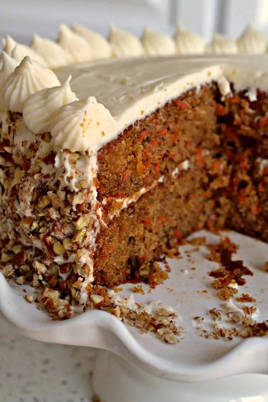 A delectable moist holiday carrot cake with a silky cream cheese frosting and chopped pecans. 