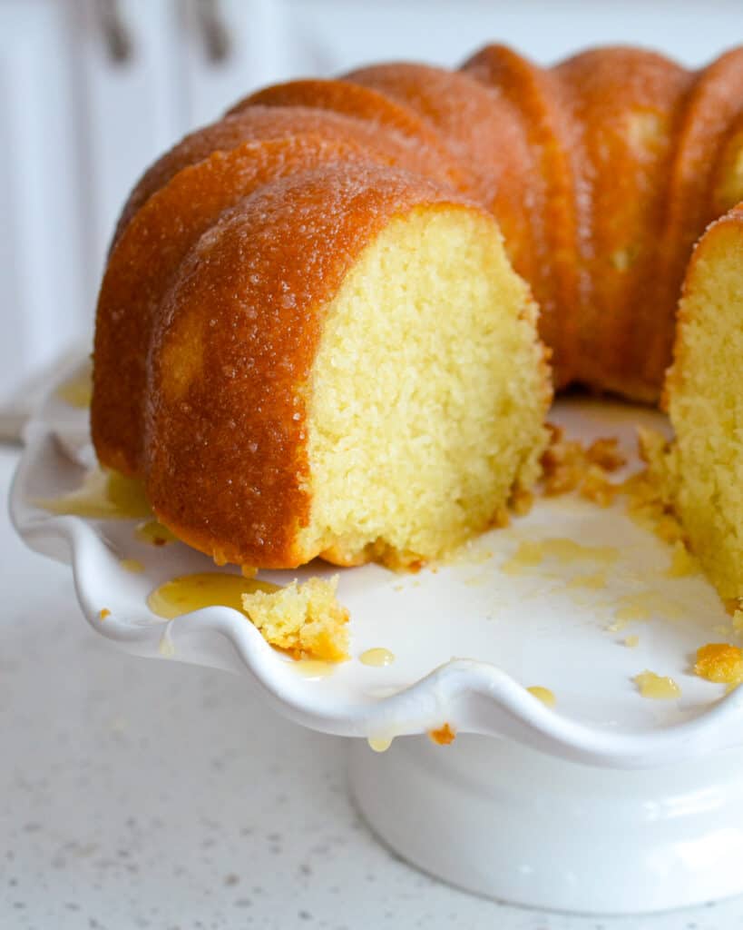 A Kentucky butter cake with a piece removed on a cake stand.