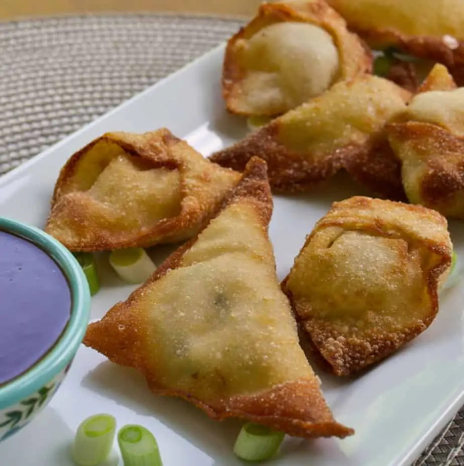crab rangoon a plate with green onions and sweet chili saucce