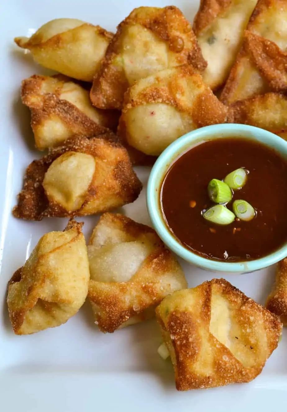Crab rangoon a plate with homemade sweet chili sauce. 