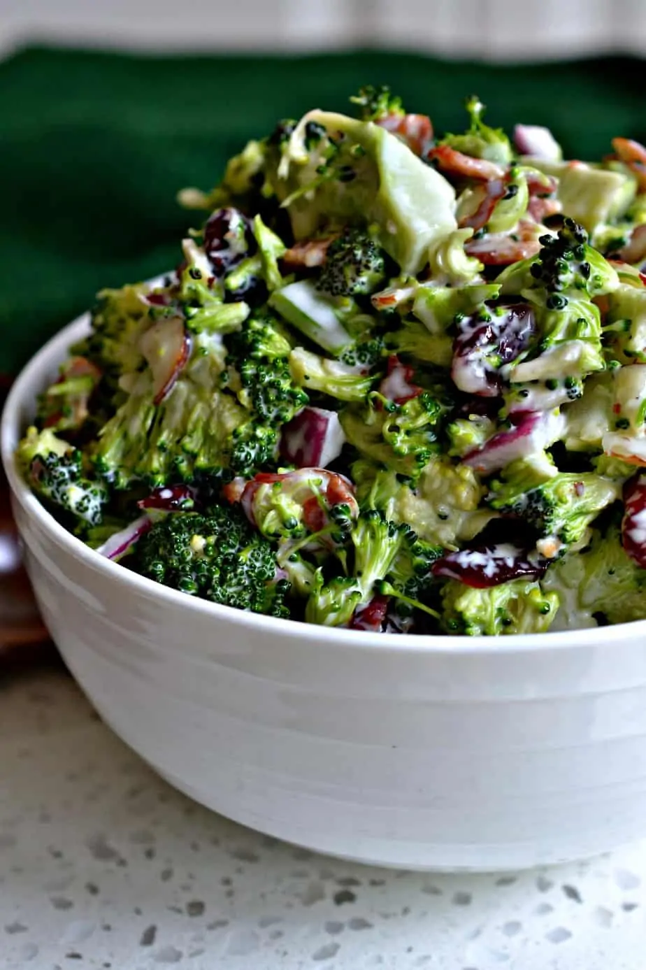 A broccoli salad made with bacon, onions, almonds, dried cranberries and a lightly sweetened easy four ingredient dressing.