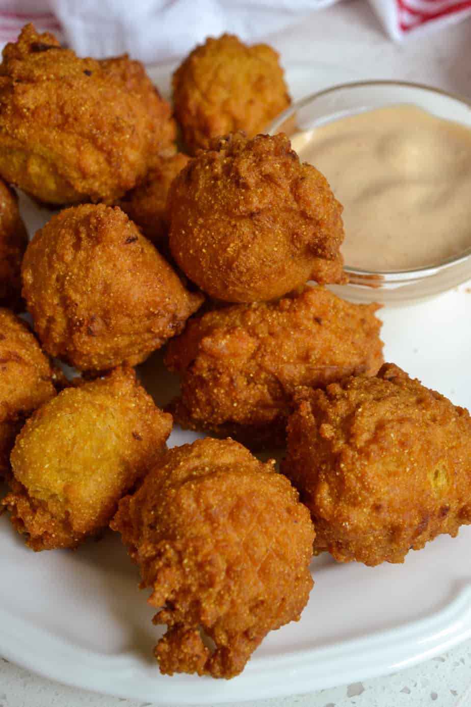 Warm and crispy fried hush puppies with a spicy southern sauce