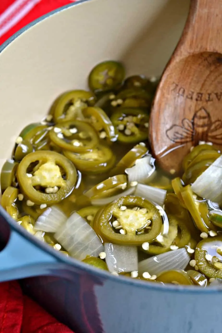 A dutch oven full of pickled jalapenos and onions