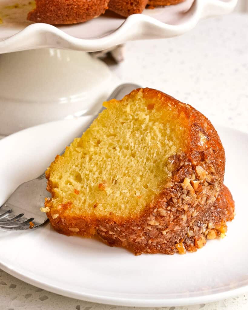 A slice of Rum Cake on a plate with a fork.