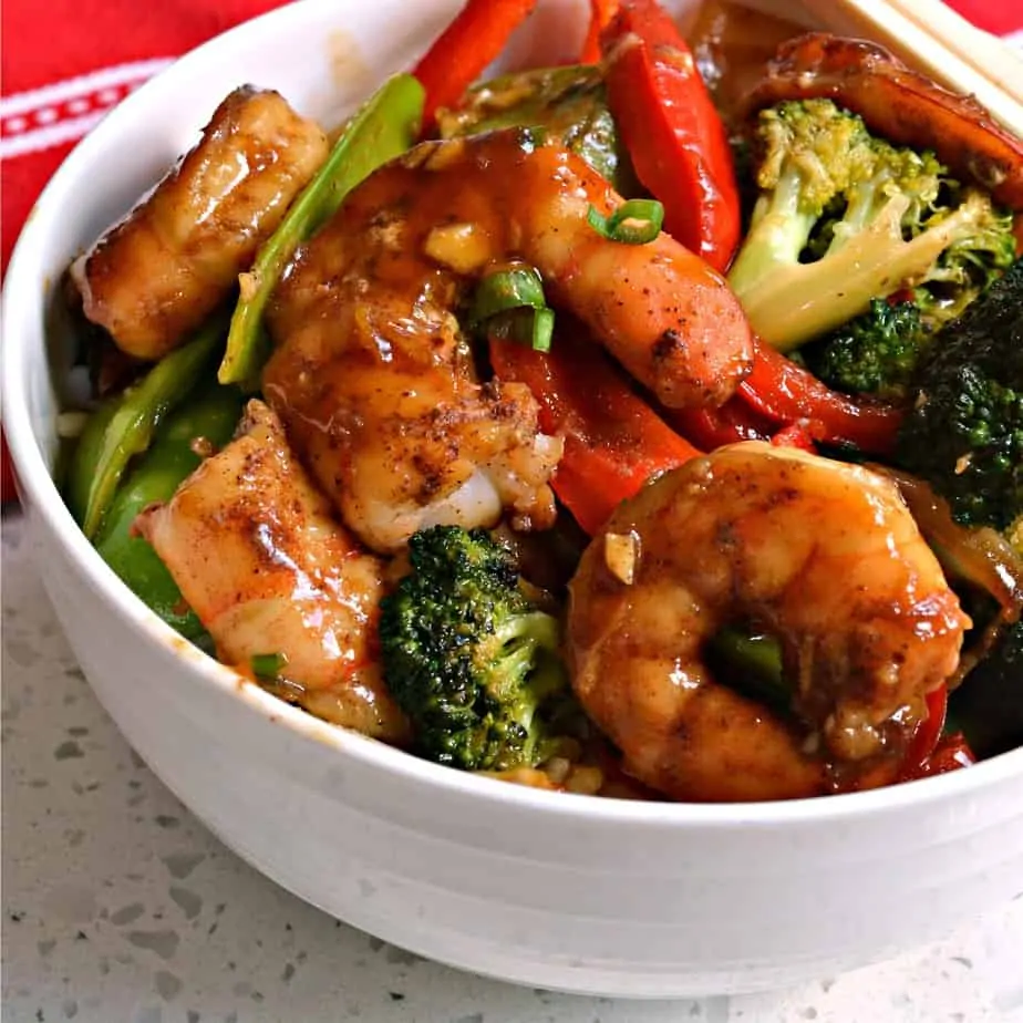 A one skillet stir fry recipe with shrimp, red peppers, onions, broccoli, snow peas and a sweet garlic ginger Asian sauce.  