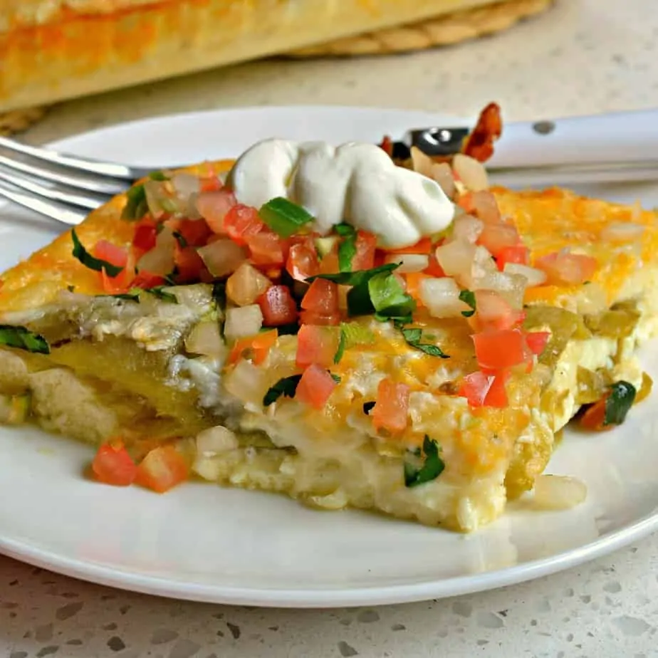 A slice of egg casserole with pico de gallo and sour cream on top