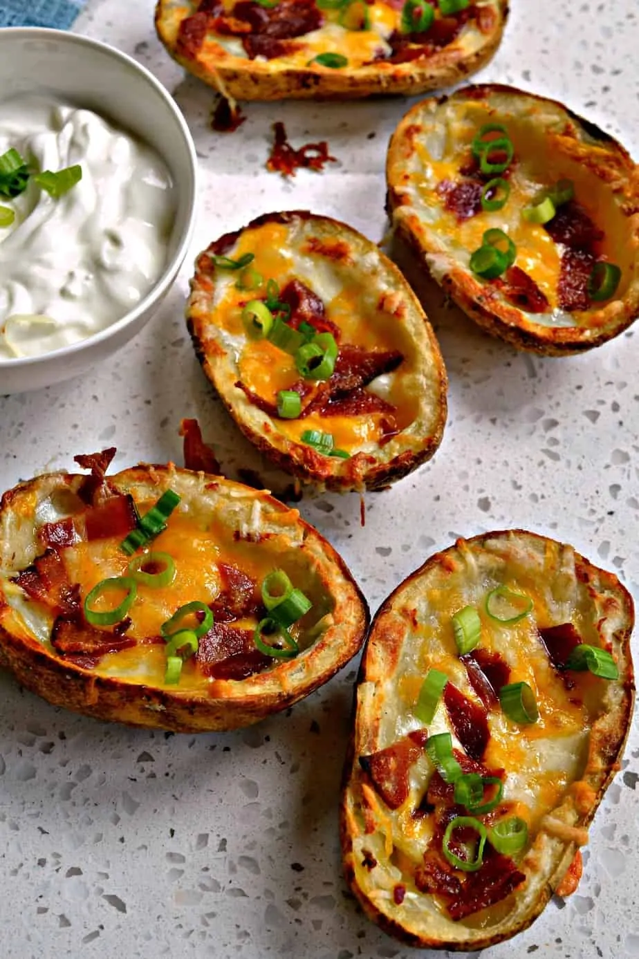These Crispy Potato skins are topped with smoked bacon, green onions, and plenty of sharp cheddar and Monterey Jack Cheese.