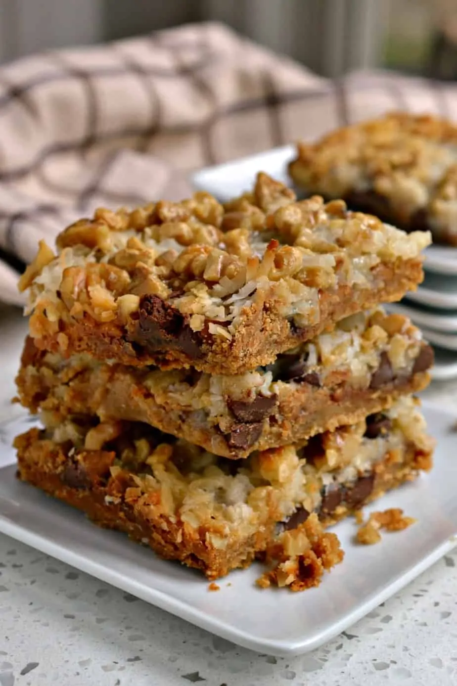 Scrumptious Magic Cookie Bars are loaded with chocolate chips, peanut butter chips, coconut, and walnuts.  
