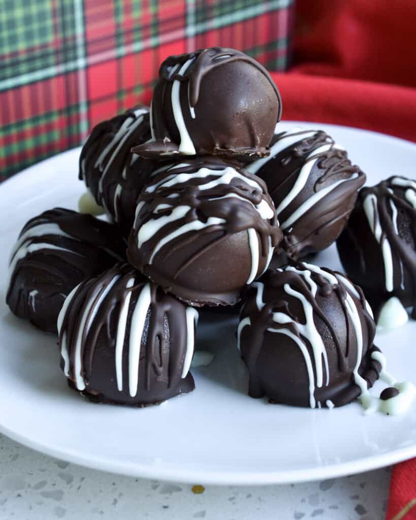 Chocolate covered cherries on a white serving plate. 