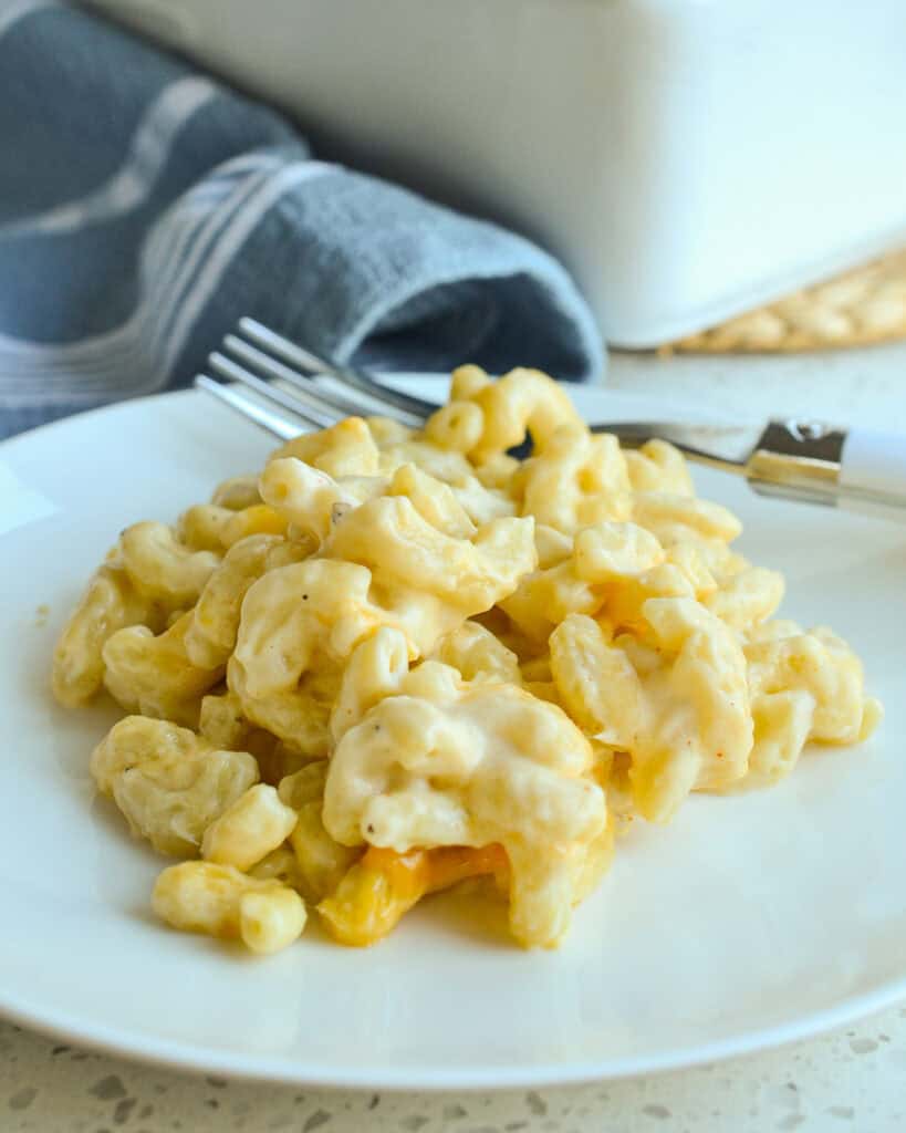 Baked Macaroni and Cheese on a white plate with a fork.