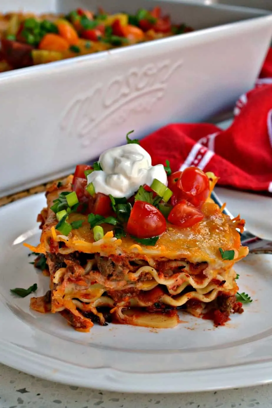 This Mexican Lasagna has layers of melted cheese, taco seasoned  ground beef, and creamy refried beans. 
