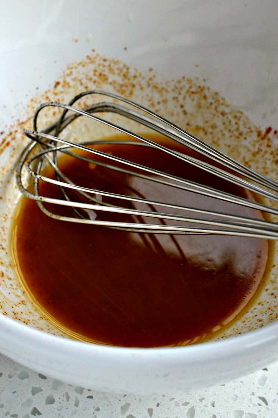 Whisk the olive oil, lime juice, chili powder, ground cumin, garlic powder, ground cayenne, and red pepper flakes in a small bowl.
