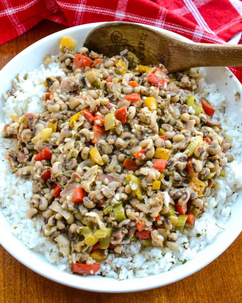 A large serving bowl full of Hoppin John over rice. 
