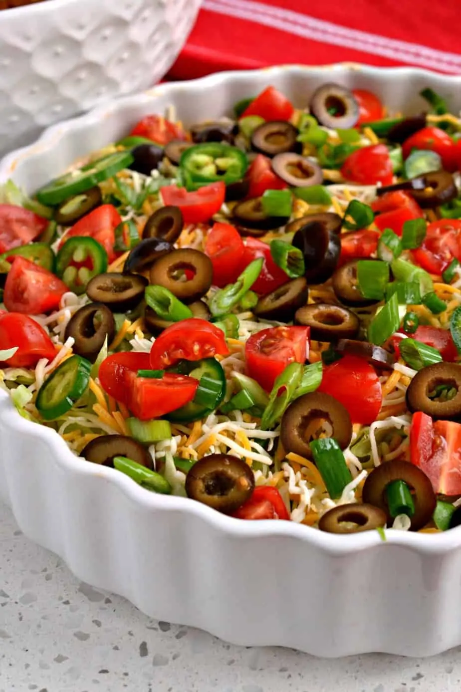 This delicious and easy Taco Dip with a sour cream and cream cheese base comes together in less than ten minutes. 