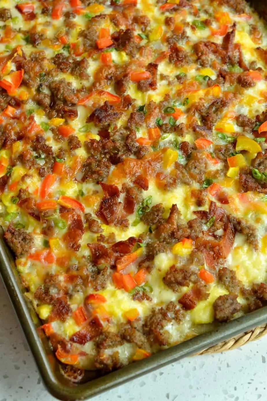 Breakfast Pizza is loaded with crispy bacon, browned pork sausage, sweet red bell pepper, scallions, scrambled eggs and eggs. 