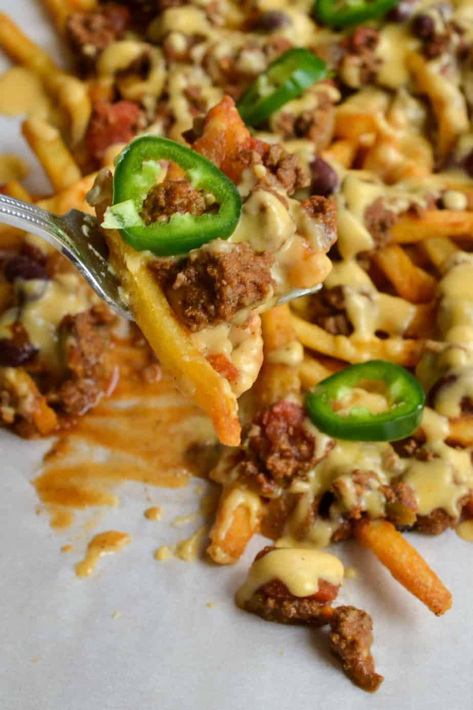 Easy Chili Cheese Fries made with crispy fries, thick hearty chili, and an easy to make creamy sharp cheddar cheese sauce.