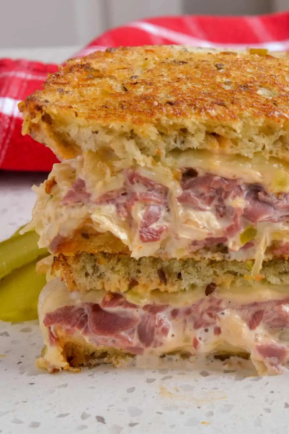  Toasted reuben with a pickle on the side. 