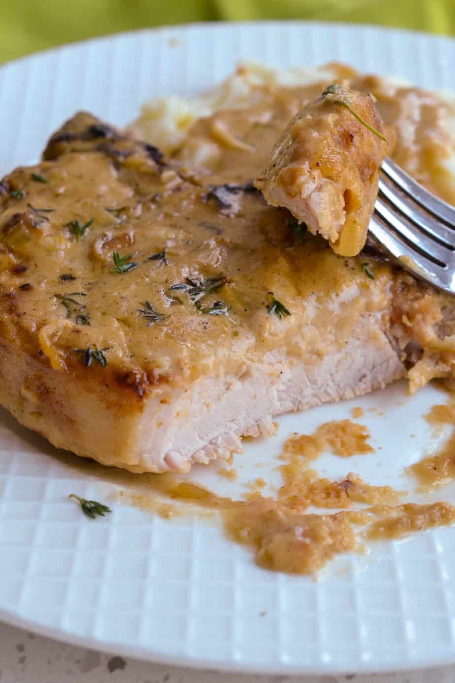 A cut pork chop with creamy gravy over the top. 