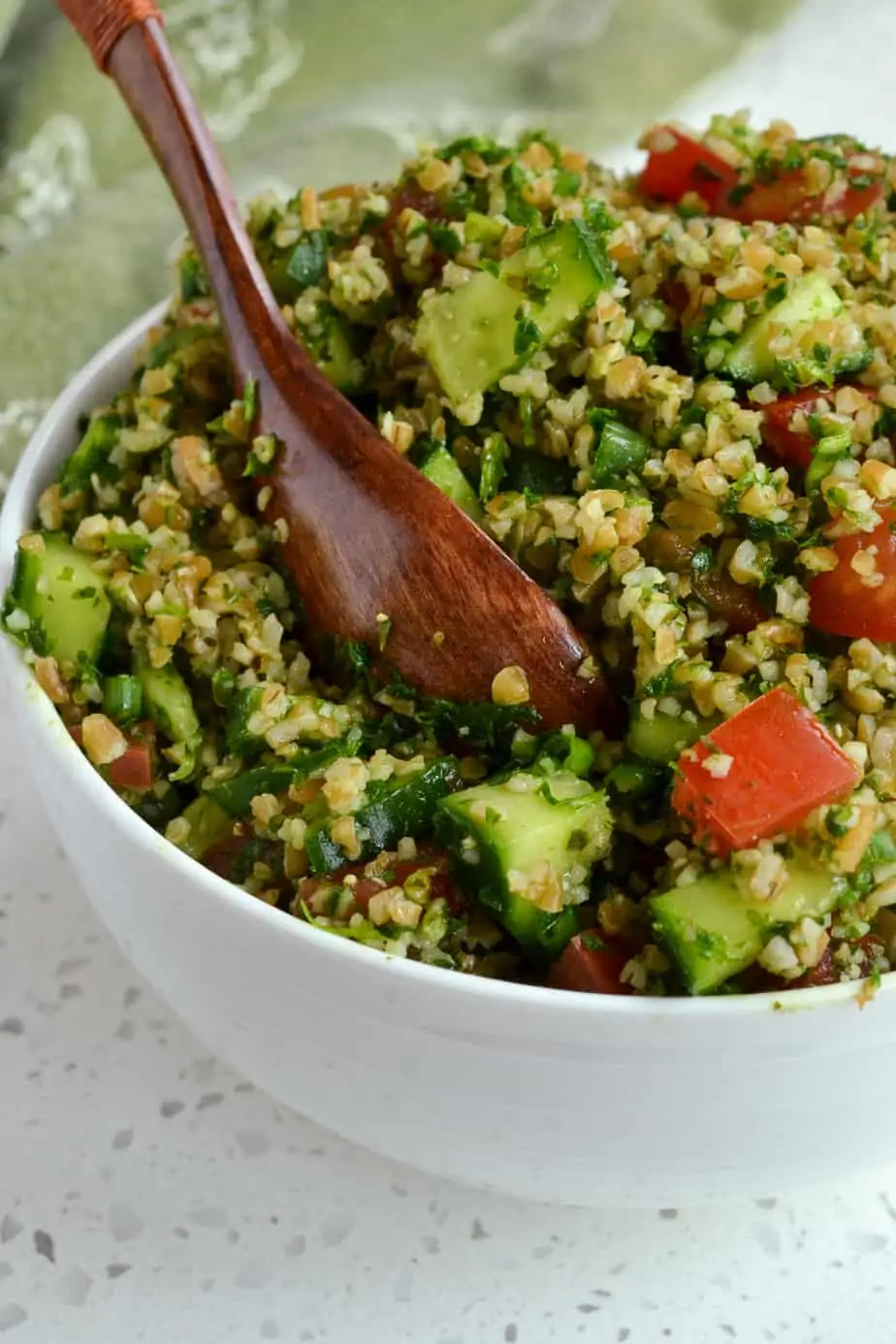 Fresh herbs, bulgur wheat, cucumbers, tomatoes and scallions all mixed together in a salad. 