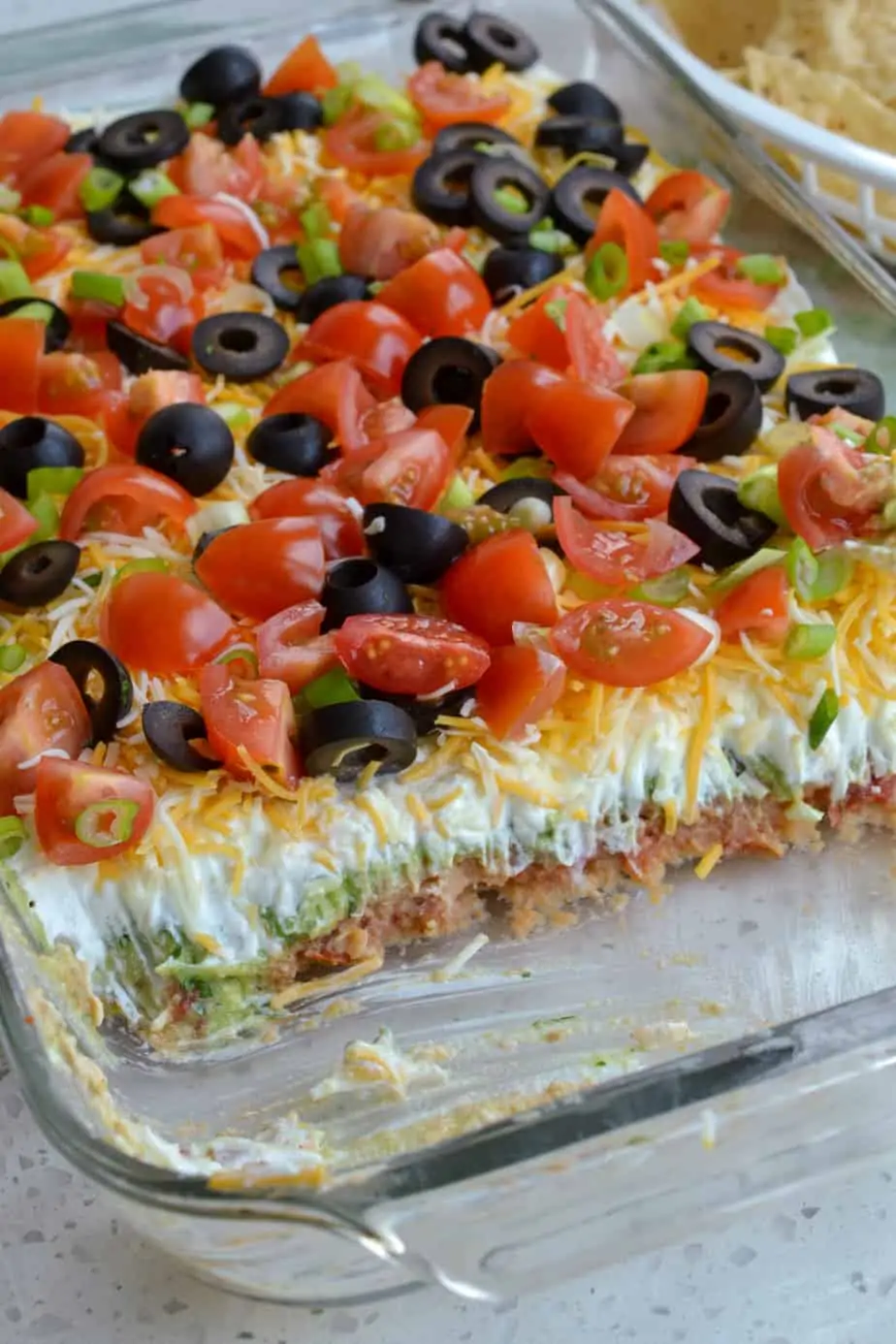 Layered bean dip with avocados and sour cream. 