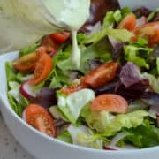 Avocado Ranch Dressing poured on a garden salad